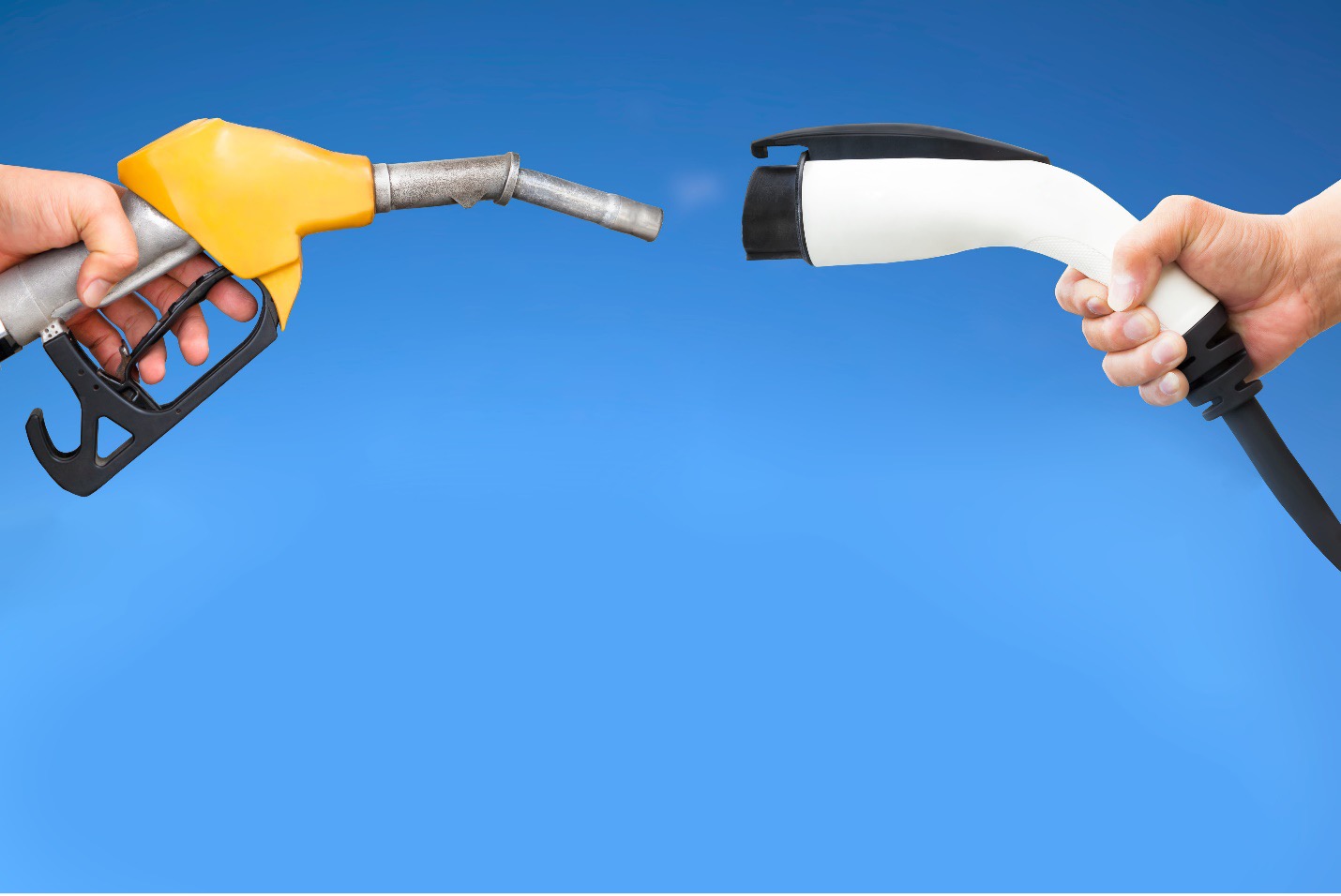 تصویر شارژر خودروی برقی و نازل بنزین در مقاله مقایسه خودروهای برقی و هیبریدی